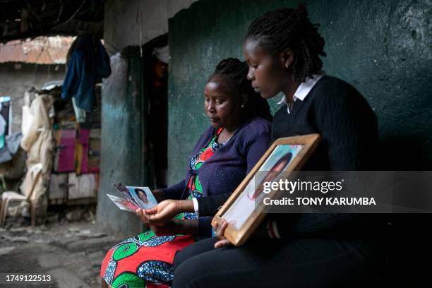 Rose Wanjiku reacts as she sits outside her residence with a relative looking at photos of her belated sister, Agnes, in Nanyuki town, Laikipia...