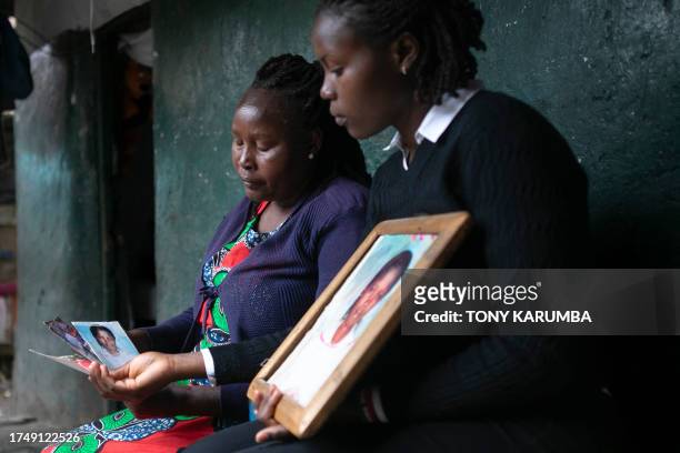 Rose Wanjiku reacts as she sits outside her residence with a relative looking at photos of her belated sister, Agnes, in Nanyuki town, Laikipia...