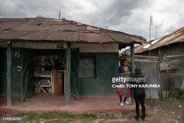 Rose Wanjiku is pictured outside her retail business premises with a relative, behind her home where she lived with her belated sister, Agnes, in...
