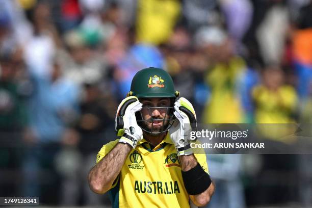 Australia's Glenn Maxwell adjusts his helmet during the 2023 ICC Men's Cricket World Cup one-day international match between Australia and New...