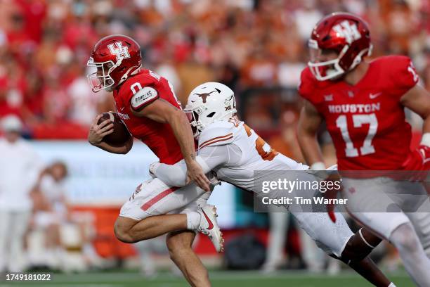 Joseph Manjack IV of the Houston Cougars is tackled by Kitan Crawford of the Texas Longhorns in the second half at TDECU Stadium on October 21, 2023...