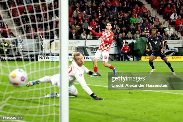 Kingsley Coman of Bayern Munich scores the team's first goal past Robin Zentner of 1.FSV Mainz 05 during the Bundesliga match between 1. FSV Mainz 05...