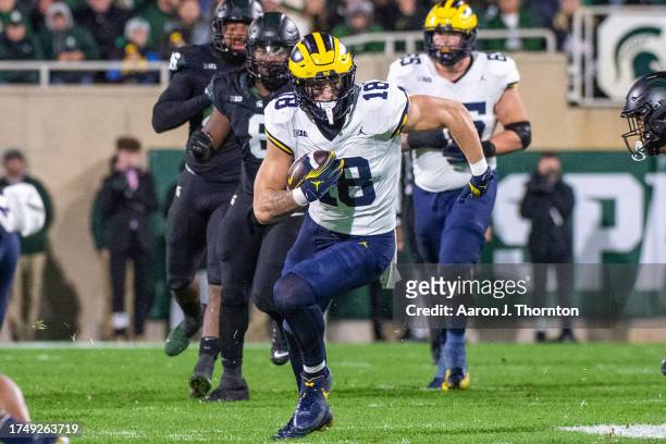 Colston Loveland of the Michigan Wolverines runs with the ball during the first half of a college football game against the Michigan State Spartans...