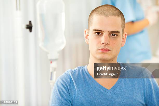 junger mann, bekommen eine chemotherapie wie zu hause fühlen. - cancer portrait stock-fotos und bilder