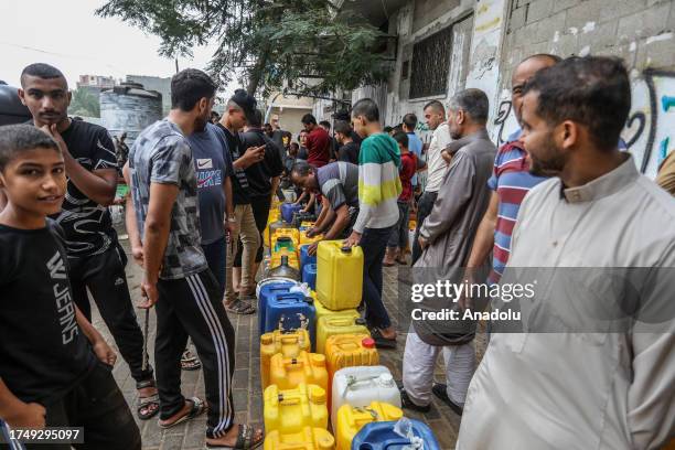 People line up in front of a water tank with their bottles due to water crisis as a result of the suspension of water flow in the water pipes from...