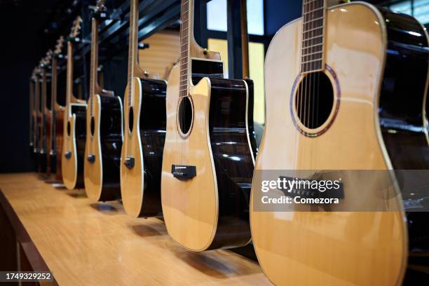 side view of guitar at display rack - guitar collection stock pictures, royalty-free photos & images