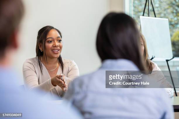 in a meeting with a panel of spectators, a young woman assumes the role of the leader - town hall stock pictures, royalty-free photos & images