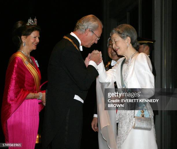 Swedish King Carl XVI Gustaf greets Empress Michiko , as Queen Silvia and Japanese Emperor Akihito look on, prior to their dinner at the Imperial...