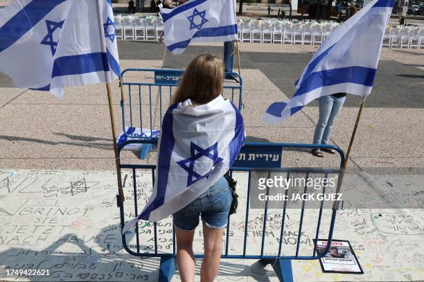 Protester wrapped in the Israeli flag, takes part in a rally calling for the release of hostages held by Palestinian Hamas gunmen since the October 7...