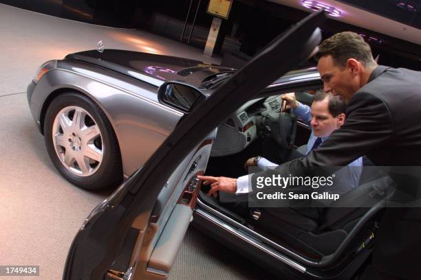Salesman shows a potential customer details of a Maybach 57 limousine, which retails for EUR 359 about $390 at a Maybach dealership January 28, 2003...