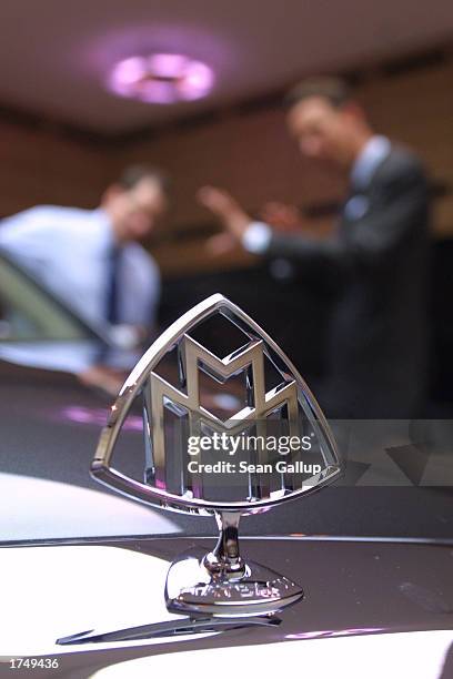 The Maybach hood ornament is visible as a salesman shows a potential customer details of a Maybach 57 limousine, which retails for EUR 359...