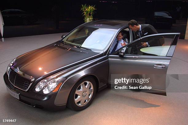 Salesman shows a potential customer details of a Maybach 57 limousine, which retails for EUR 359 approximately $390 sits at a Maybach dealership...