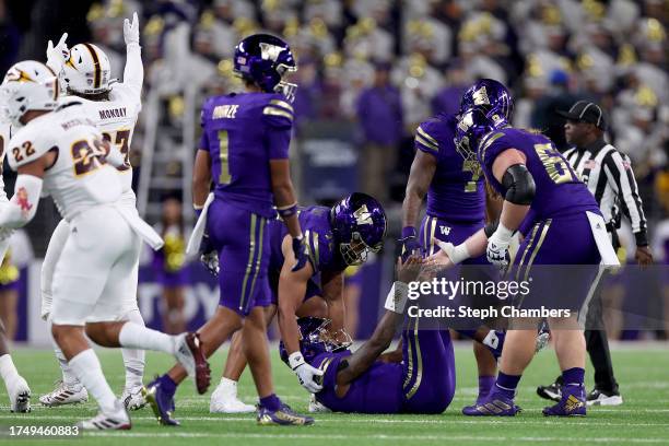 Michael Penix Jr. #9 of the Washington Huskies is helped up after a fumble against the Arizona State Sun Devils during the second quarter at Husky...