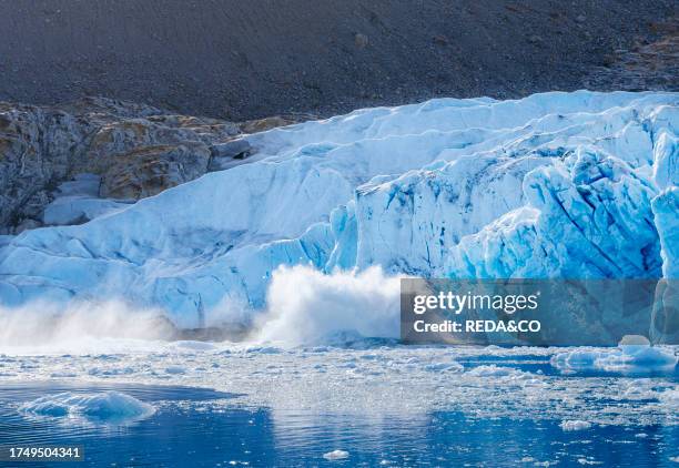 Calfing of an iceberg at Brueckner Glacier with view of lateral moraine dating back to the 1900s indicating mass loss. Landscape in the Johan...