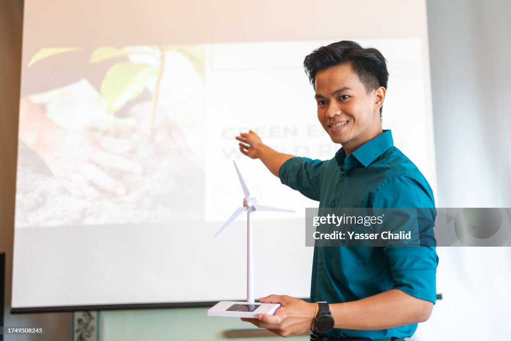 Asian man showing wind turbine at business conference