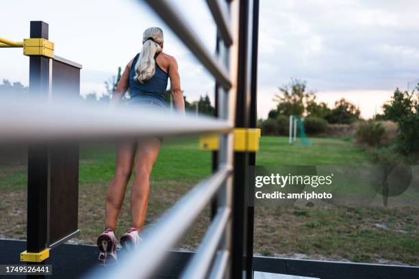 woman during bodyweight training at calisthenics outdoor gym - bodyweight training stock pictures, royalty-free photos & images