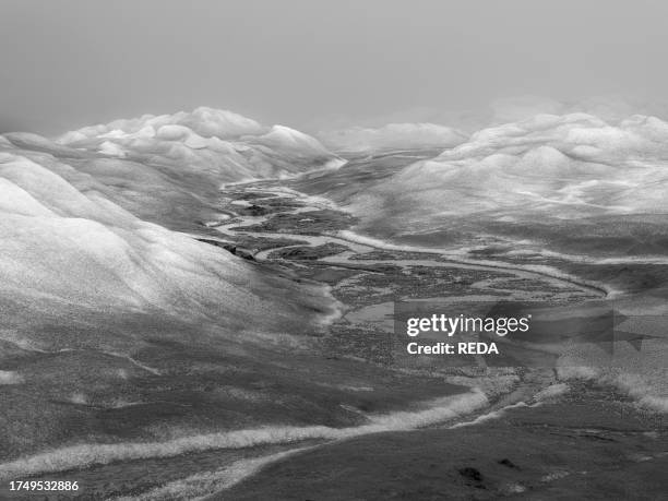 Drainage system on the surface of the ice sheet. The brown sediment on the ice is created by the rapid melting of the ice. Landscape of the Greenland...