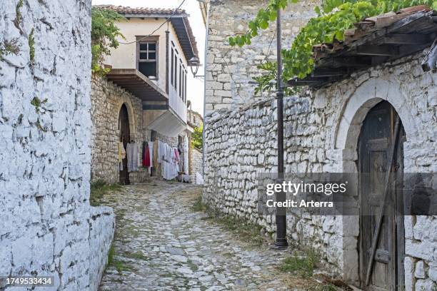 Narrow alley with cobblestones on Castle Hill, old quarter with Ottoman houses in the city Berat. Berati, southern Albania.