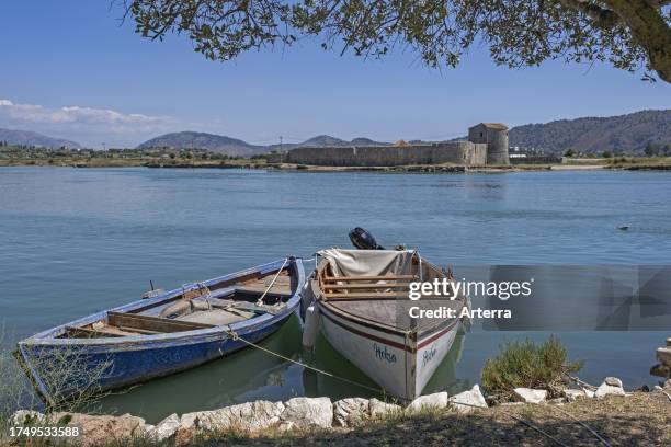 Fishing boats and 15th century Venetian Triangular Castle along the Vivari Channel near Butrint National Park, Vlorë County, southern Albania.