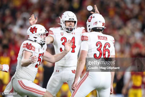 Cole Becker of the Utah Utes celebrates his field goal to win the game with Jack Bouwmeester and JT Greep of the Utah Utes against the USC Trojans in...