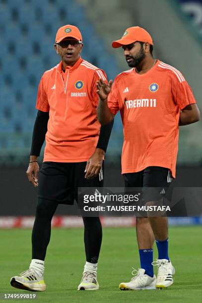 India's captain Rohit Sharma and coach Rahul Dravid speak during a practice session on the eve of their 2023 ICC Men's Cricket World Cup one-day...