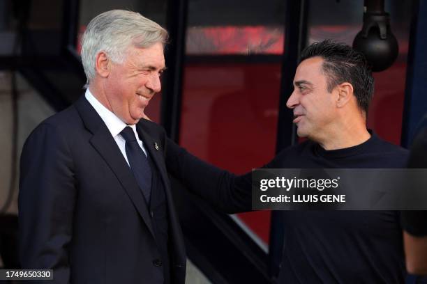 Real Madrid's Italian coach Carlo Ancelotti and Barcelona's Spanish coach Xavi greet each other before the Spanish league football match between FC...