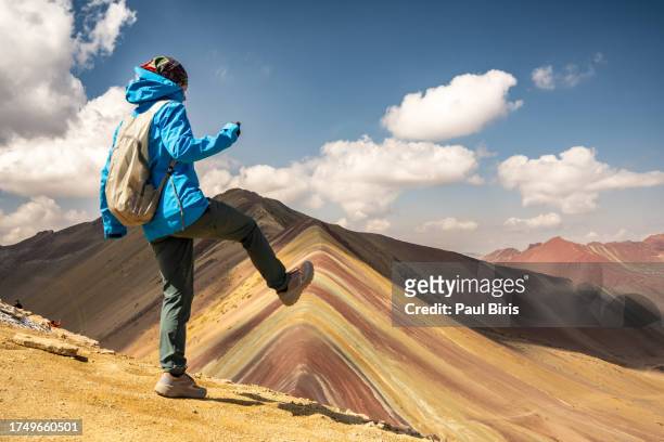 jumping on the summit of rainbow mountain in cusco, vinicunca rainbow mountain or montana de siete colores, peru - vinicunca photos et images de collection
