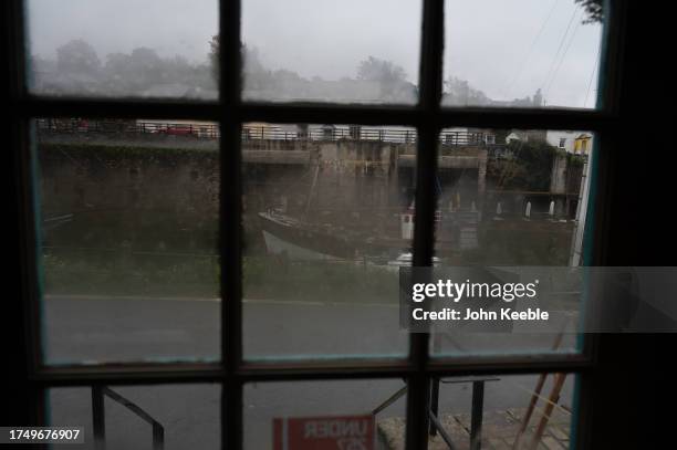 General view of a boat through a door window of a pub on an overcast wet day in Charlestown Harbour, a Unesco World Heritage Site on September 17,...