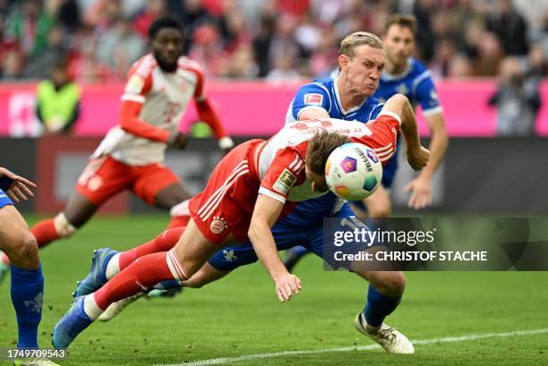 Bayern Munich's English midfielder Harry Kane heads the first goal for Munich against Darmstadt's Austrian defender Christoph Klarer during the...