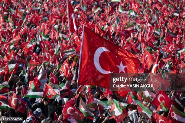 People wave Turkish and Palestinian flags as Turkish President speaks during a rally organised by the AKP party in solidarity with the Palestinians...