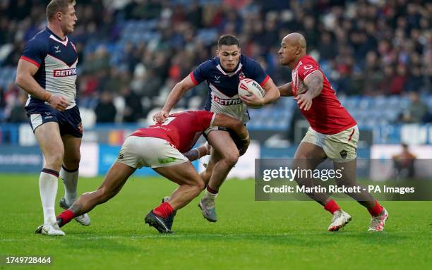 England's Jack Welsby is tackled by Tonga's Tyson Frizell and Felise Kaufusi during the International Test Series match at John Smith's Stadium,...