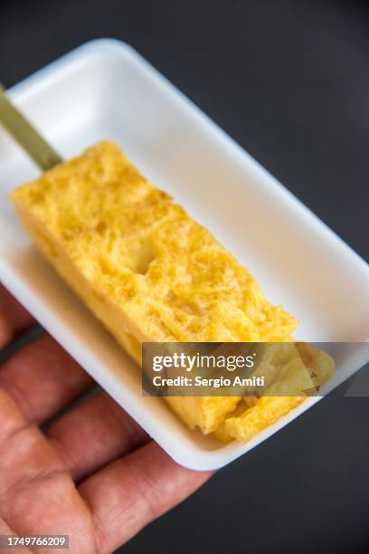 tamago-yaki (japanese rolled-egg omelette) kushi-tama (omelette on a stick) - dashimaki tamago fotografías e imágenes de stock