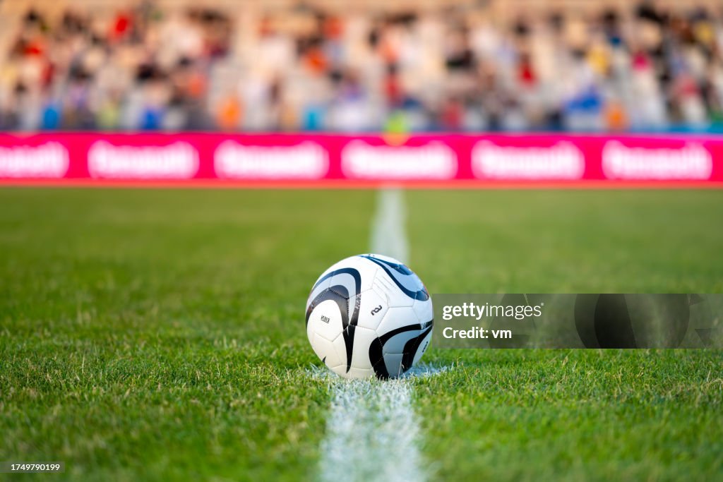 Soccer ball on white halfway line on field