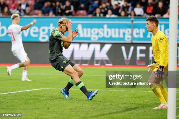 October 2023, Bavaria, Augsburg: Soccer: Bundesliga, FC Augsburg - VfL Wolfsburg, Matchday 9, WWK Arena. Sebastiaan Bornauw of VfL Wolfsburg grabs...