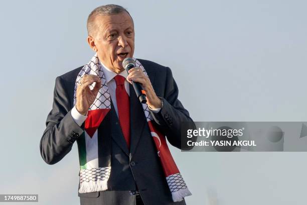 Turkish President Recep Tayyip Erdogan wears a scarf with both Turkish and Palestinian flags as he addresses a rally organised by the AKP party in...
