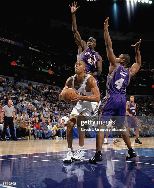 Brown of the New Orleans Hornets covered by Bo Outlaw and Alton Ford of the Phoenix Suns goes to shoot during the game at New Orleans Arena on...