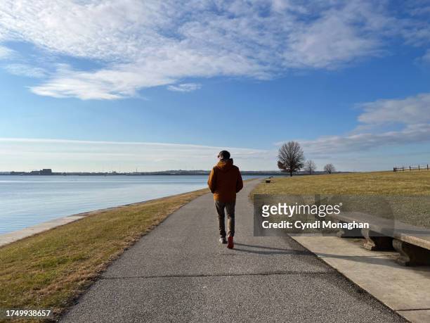 man walking at fort mchenry in winter. - baltimore maryland landscape stock pictures, royalty-free photos & images
