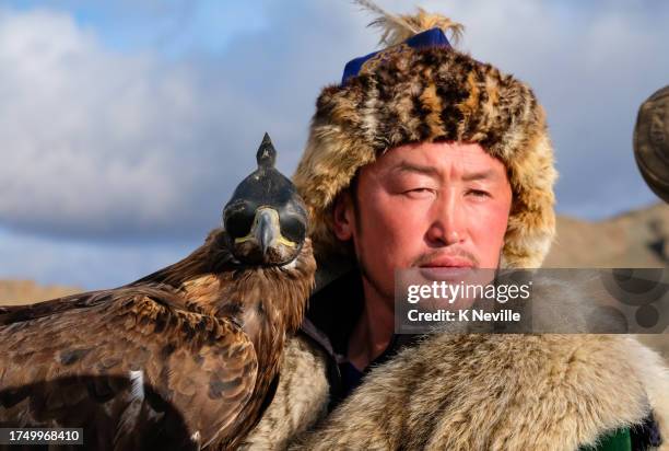 nomadic eagle hunter with his hooded golden eagle - mongolian culture stock pictures, royalty-free photos & images
