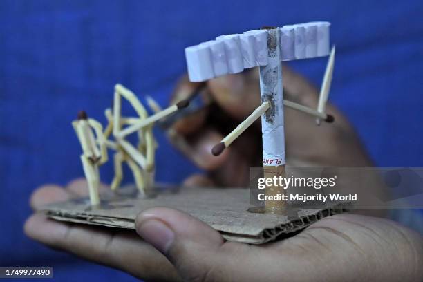 Bijoy Debnath, a 21 year old artist showing his art work created with matchsticks and cigarettes depicting a matchstick man killing a cigarette with...