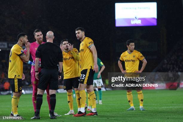 Wolves players appeal to English referee Anthony Taylor as the VAR analyses a possible penalty offence from Wolverhampton Wanderers' South Korean...