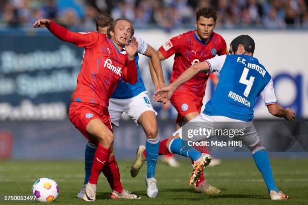 Fiete Arp of Holstein Kiel battles for possession with Damian Rossbach of F.C. Hansa Rostock during the Second Bundesliga match between F.C. Hansa...