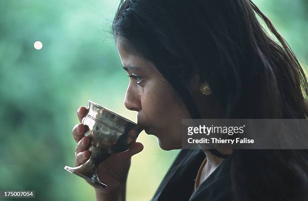 Young woman drinks tea in a private house..