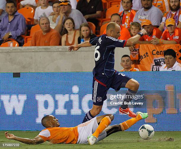 Joel Lindpere of Chicago Fire eludes a sliding tackle by Ricardo Clark of Houston Dynamo at BBVA Compass Stadium on July 27, 2013 in Houston, Texas.