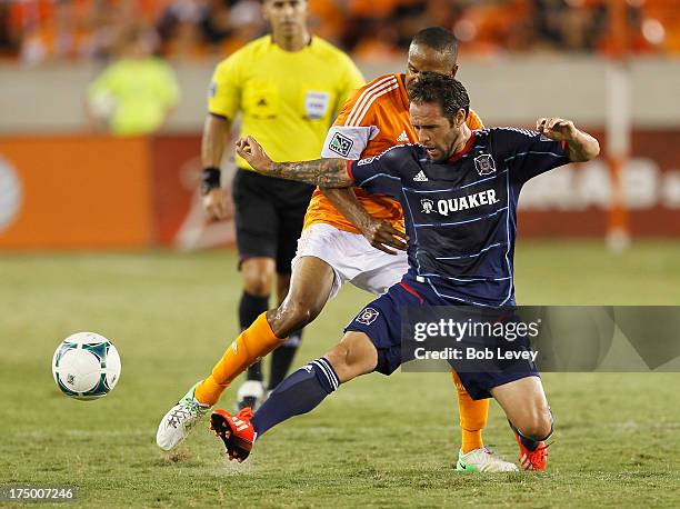 Daniel Paladini of Chicago Fire loses control of the ball as he defended by Ricardo Clark of Houston Dynamo at BBVA Compass Stadium on July 27, 2013...