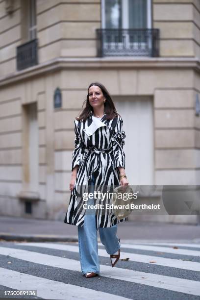 Alba Garavito Torre wears a white t-shirt from Zara, black and white zebra print illustration by Chafik Cheriet trench by AZ Factory, wide-leg jeans...