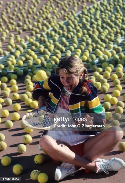 Portrait of Tracy Austin bouncing ball on racket on court covered with tennis balls during photo shoot at Jack Kramer Tennis Club. Rolling Hills...