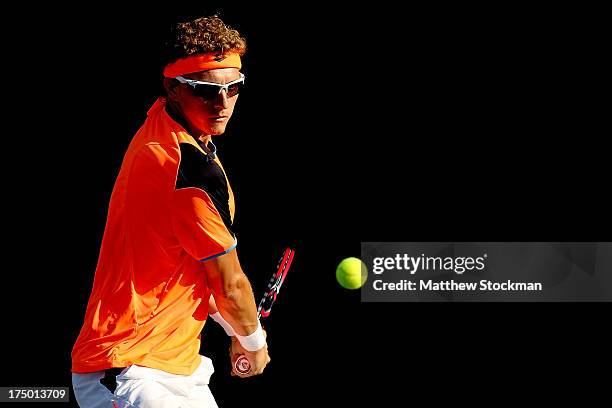 Denis Istomin of Uzebekistan returns a shot to Santiago Giraldo of Columbia during the Citi Open at the William H.G. FitzGerald Tennis Center on July...