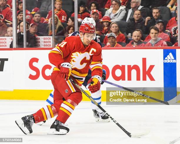 Mikael Backlund of the Calgary Flames in action against the Winnipeg Jets during an NHL game at Scotiabank Saddledome on October11, 2023 in Calgary,...