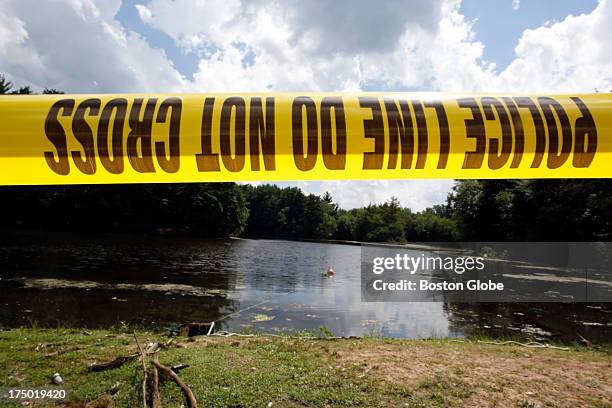 Police tape is seen in front of Pine Lake as Connecticut State Police officers search the Lake looking for a gun that police believe was used to kill...