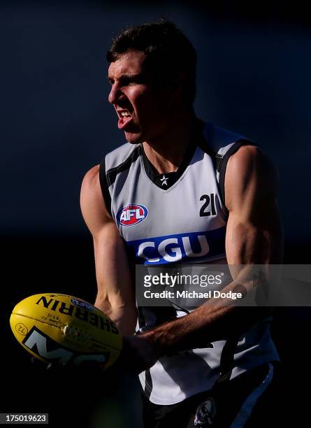 Quinten Lynch handpasses the ball during a Collingwood Magpies AFL training session at Olympic Park on July 30, 2013 in Melbourne, Australia.